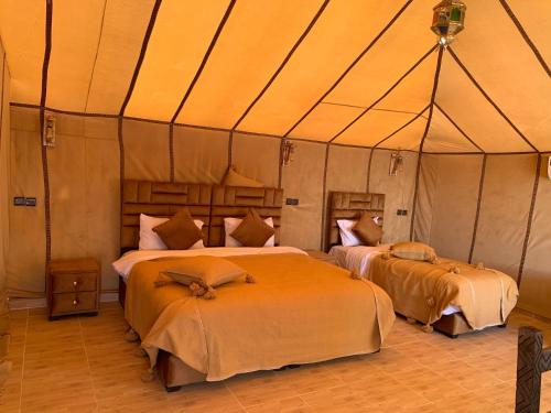 1 dormitorio con 2 camas en una tienda de campaña en Luxury white camp, en Merzouga