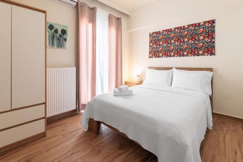 a bedroom with a bed and a painting on the wall at Rotunda Living Nr12 in Thessaloniki