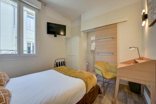 a bedroom with a bed and a desk and a window at Urban Style Hotel Blason du Ventoux in Carpentras
