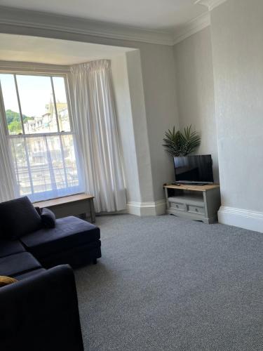 a living room with a couch and a television at Puffins Nest, close to Tunnels Beach & Harbour with Parking in Ilfracombe