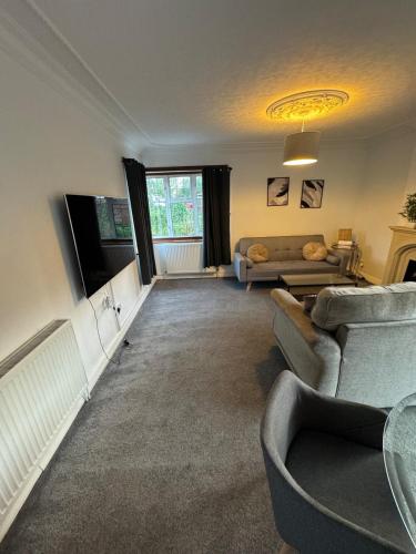 a living room with a couch and a tv at Four BDR House By Eason Stays Short Lets & Serviced Accommodation Rugby With Free Parking in Hillmorton