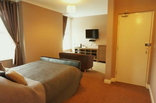 a hotel room with a bed and a television at shoreside inn in Shanklin