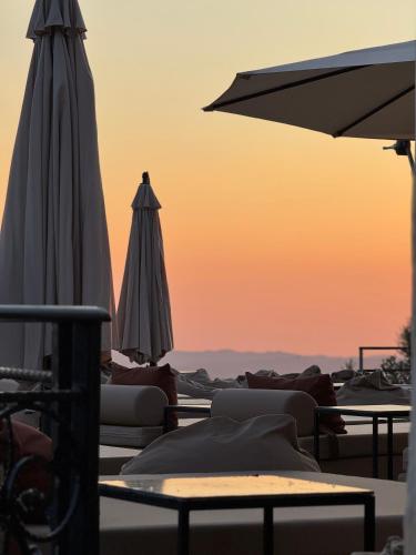 a patio with umbrellas and chairs and a table at Chateau Fasel in Tirana