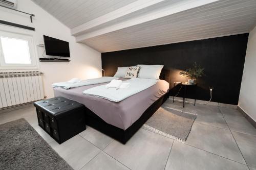 a bedroom with a large bed with a black wall at Villa Ema in Drniš