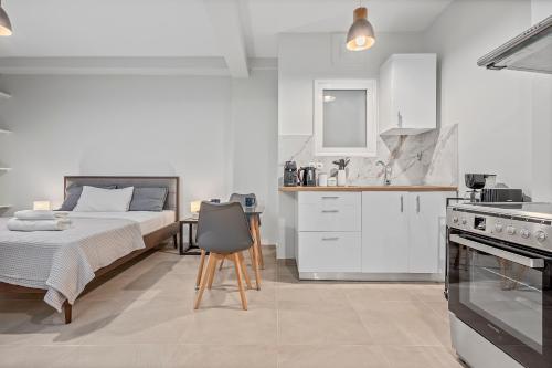 a white bedroom with a bed and a kitchen at Athens Urban Lifestyle Apartments in Athens