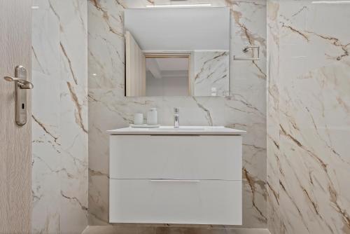 a white bathroom with a sink and a mirror at Athens Urban Lifestyle Apartments in Athens