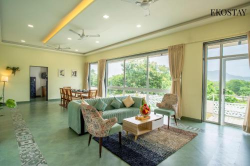 una sala de estar con un sofá y una mesa en EKOSTAY - Alpine Villa, en Alibaug