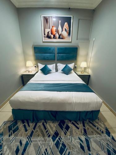 a bedroom with a large bed with a blue headboard at جناح ديلوكس غرفة وصالة في موقع مميز - مرخصة ضيافة خاصة - in Khamis Mushayt