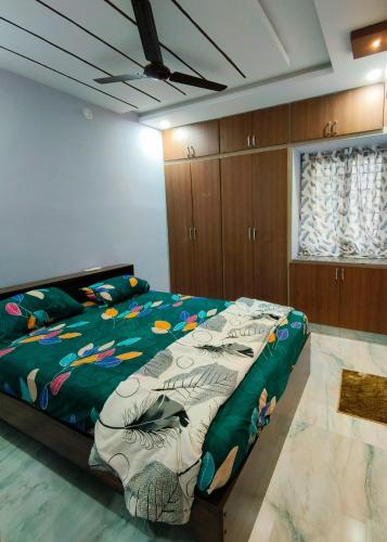 a bedroom with a bed with a green comforter at Comfortable Budget Stay at ServoStay NonAC Rooms in Tirupati Ideal for Pilgrims in Tirupati