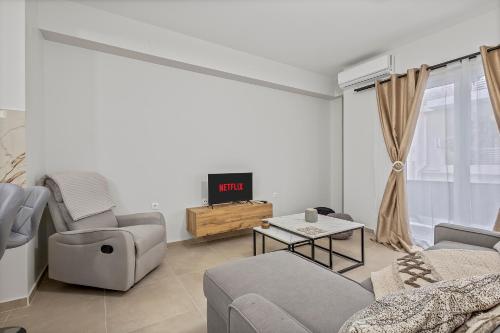 a living room with a couch and a tv at Athens Urban Lifestyle Apartments in Athens