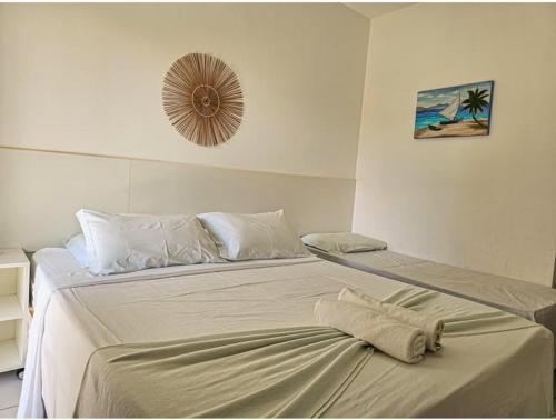 a bedroom with a large bed and a mirror on the wall at Pousada Solar da Praia in Tamandaré