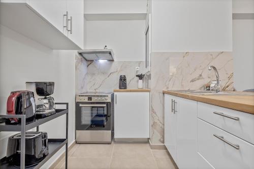a kitchen with white appliances and marble walls at Athens Urban Lifestyle Apartments in Athens
