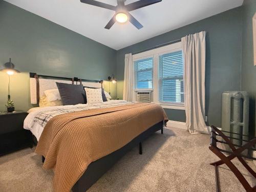 una camera da letto con un letto e un ventilatore a soffitto di Chic Lakeside Retreat Steps from the Beach a Cleveland
