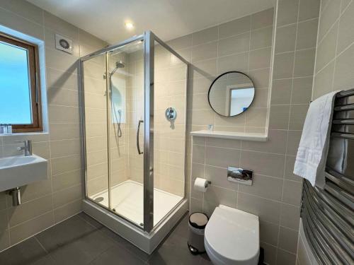 a bathroom with a shower and a toilet and a sink at House 32 in Looe