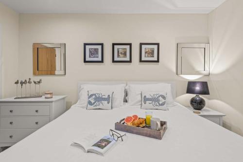 a white bed with a tray of fruit on it at House 35 in Looe