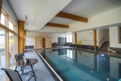 a large swimming pool with a table and chairs at House 35 in Looe