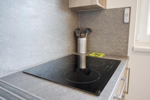 a kitchen counter with a stove top with yellow scissors at Bohemian Glow of Krumlov in Český Krumlov
