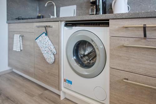 a washing machine in a kitchen with a counter at Bohemian Glow of Krumlov in Český Krumlov
