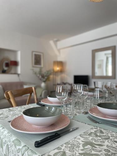 a table with plates and wine glasses on it at Le petit traîne-feuilles in Saint-Aignan