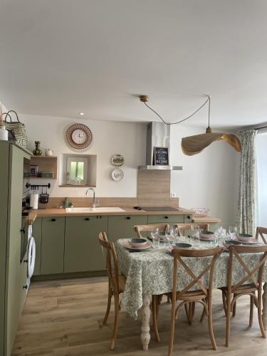 a kitchen with a table and some chairs and a kitchen at Le petit traîne-feuilles in Saint-Aignan
