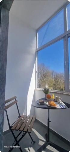 a table and a chair in front of a window at Joana's room 2 in Lisbon