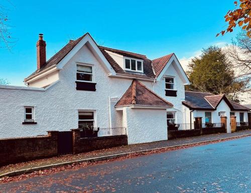 a white house on the side of a street at 6 Luxury home near family park Pet friendly in Merthyr Tydfil