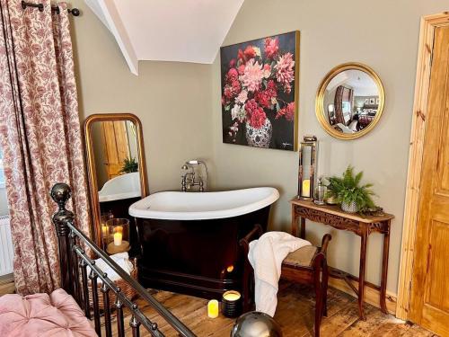 a bathroom with a bath tub and a mirror at 6 Luxury home near family park Pet friendly in Merthyr Tydfil