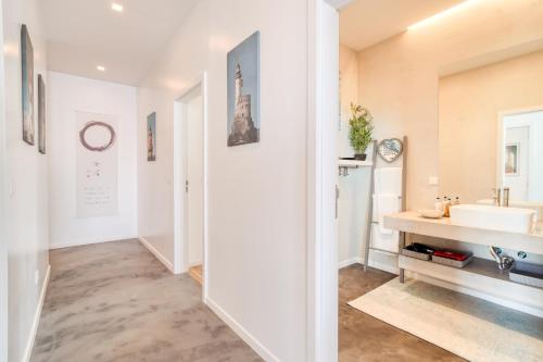 a white bathroom with a sink and a mirror at Casa Luz by LovelyStay in Prazeres