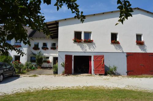 ein weißes Haus mit roten Türen und Blumen an den Fenstern in der Unterkunft Lindenhof Hahn in Blankenrath