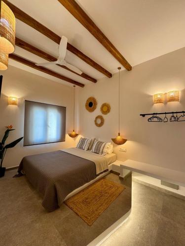 a bedroom with a bed and a large window at Cycladic Sand The House in Ios Chora