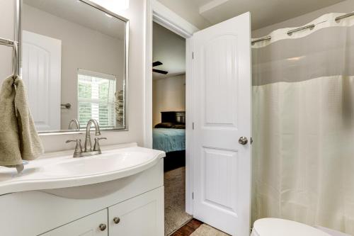 Un baño blanco con lavabo y espejo. en Riverfront Family Retreat with Yard in Saint Amant, en Port Vincent