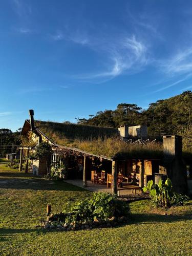 a house with a grass roof on a field at Divina Reserva Capim limão in Bom Retiro