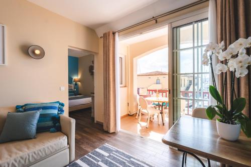 a living room with a couch and a table at Le Suffren Hôtel in Grimaud