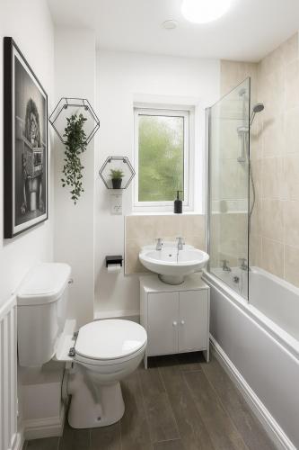 a white bathroom with a toilet and a sink at Modern 2BR Aprt Sleeps 6 Parking ,Pet Welcome in Timperley