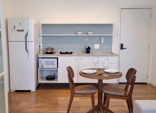 a kitchen with a table and chairs and a refrigerator at Blend Coliving One - 1 in Ribeirão Preto