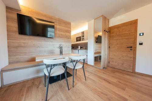 a dining room with a table and two stools at Appartements Strutzer in Sillian
