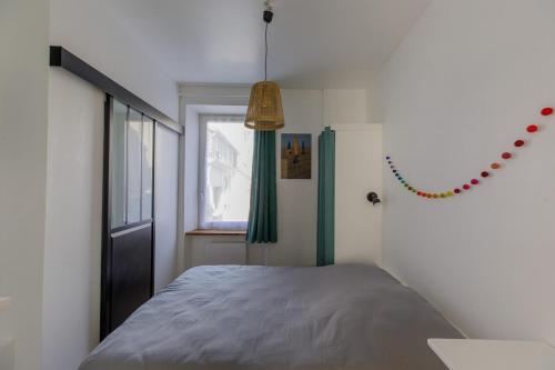 a bedroom with a bed and a window at charmant deux pièces 5 min de la plage in Concarneau