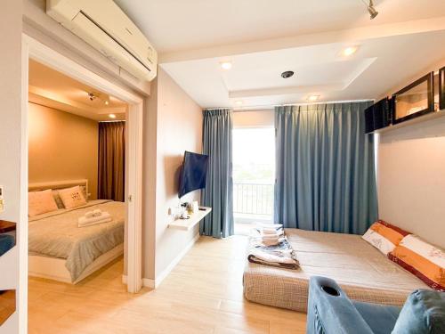 Un dormitorio con dos camas y una ventana. en Finn Room Plus 38 sqm & The Patio by BHB, en Bangsaen Sai 1