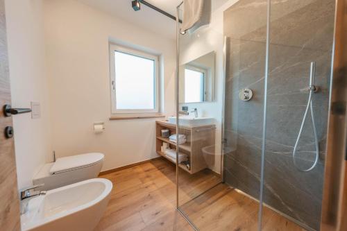 a bathroom with a shower and a toilet and a sink at Appartements Strutzer in Sillian