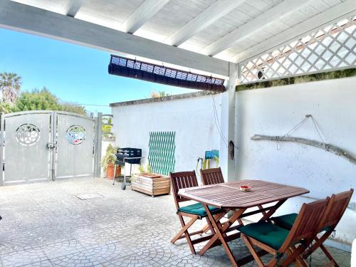a patio with a wooden table and two chairs at CASA TYCHE - grazioso alloggio a Torre dell' Orso in Torre dell'Orso