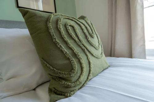 a green pillow sitting on top of a bed at 3 Bed House 9 mins walk to Anfield Sleeps 7 in Liverpool