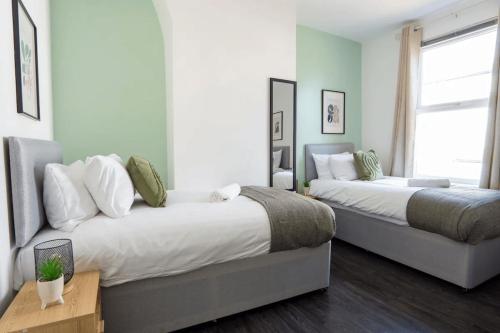 a bedroom with two beds and a couch at 3 Bed House 9 mins walk to Anfield Sleeps 7 in Liverpool