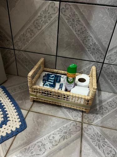 ein Korb mit Toilettenartikeln auf dem Boden eines Badezimmers in der Unterkunft Santa Maria de Nazaré in Anápolis