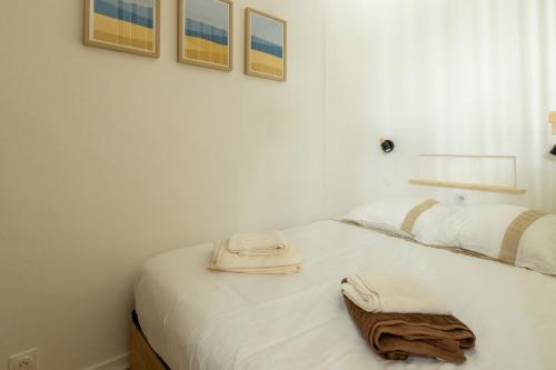 a bedroom with a white bed with towels on it at Hyper centre, résové, lave linge, wifi, coin nuit séparé in Dax
