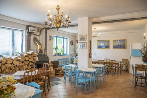 un restaurant avec des tables et des chaises bleues et une salle avec des cheminées dans l'établissement Arka Przystań, à Jastrzębia Góra