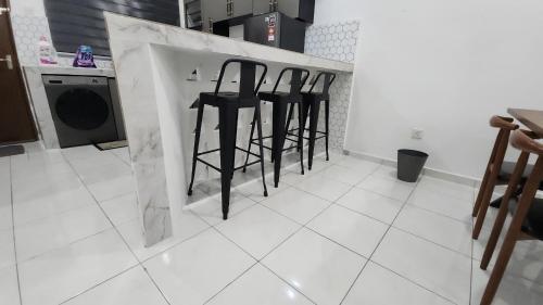 a row of black bar stools in a kitchen at Stay Put by Liza in Jasin