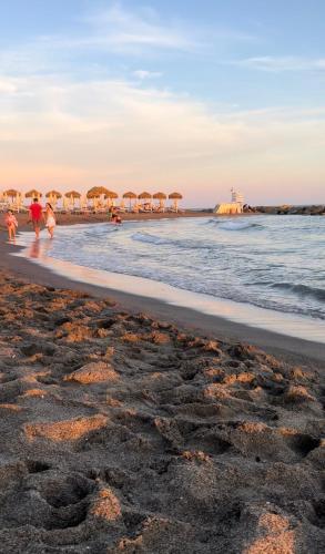 a beach with umbrellas and people walking on the beach at Casa Liliana in Ladispoli