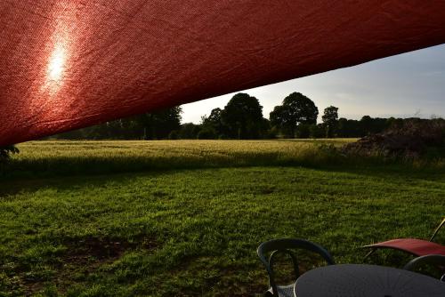 a table and chairs in a field of grass at Gîte dans la campagne Bretonne - Le jardin de Devant in Villamée