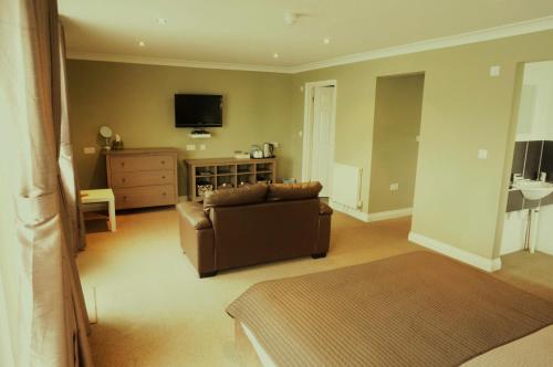 a living room with a couch and a tv at shoreside inn in Shanklin