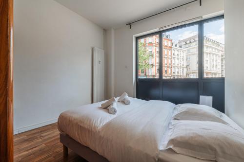 une chambre avec un lit et une grande fenêtre dans l'établissement Une Parenthèse à Strasbourg, à Strasbourg